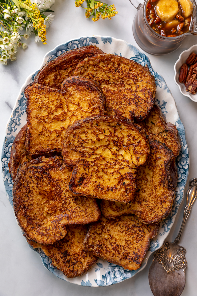 This Easy Bananas Foster French Toast is one of our favorite breakfast recipes! Crispy slices of buttery brioche are topped with a delicious homemade bananas foster sauce made from dark rum, butter, brown sugar, heavy cream, and crunchy pecans. Delicious on it's on, but devilishly good with whipped cream or vanilla ice cream!